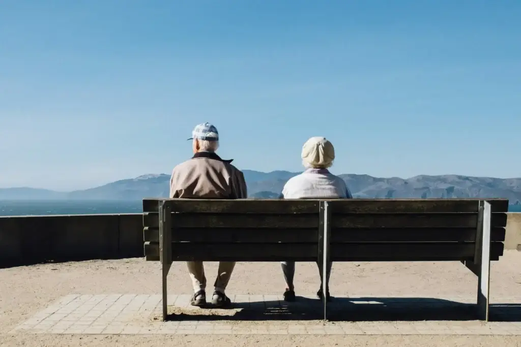 A couple sitting on a bench looking at the scenery, a moment of rest
